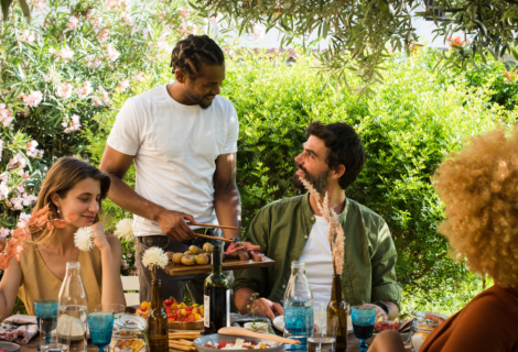 four young adults around a table at an outside barbecue