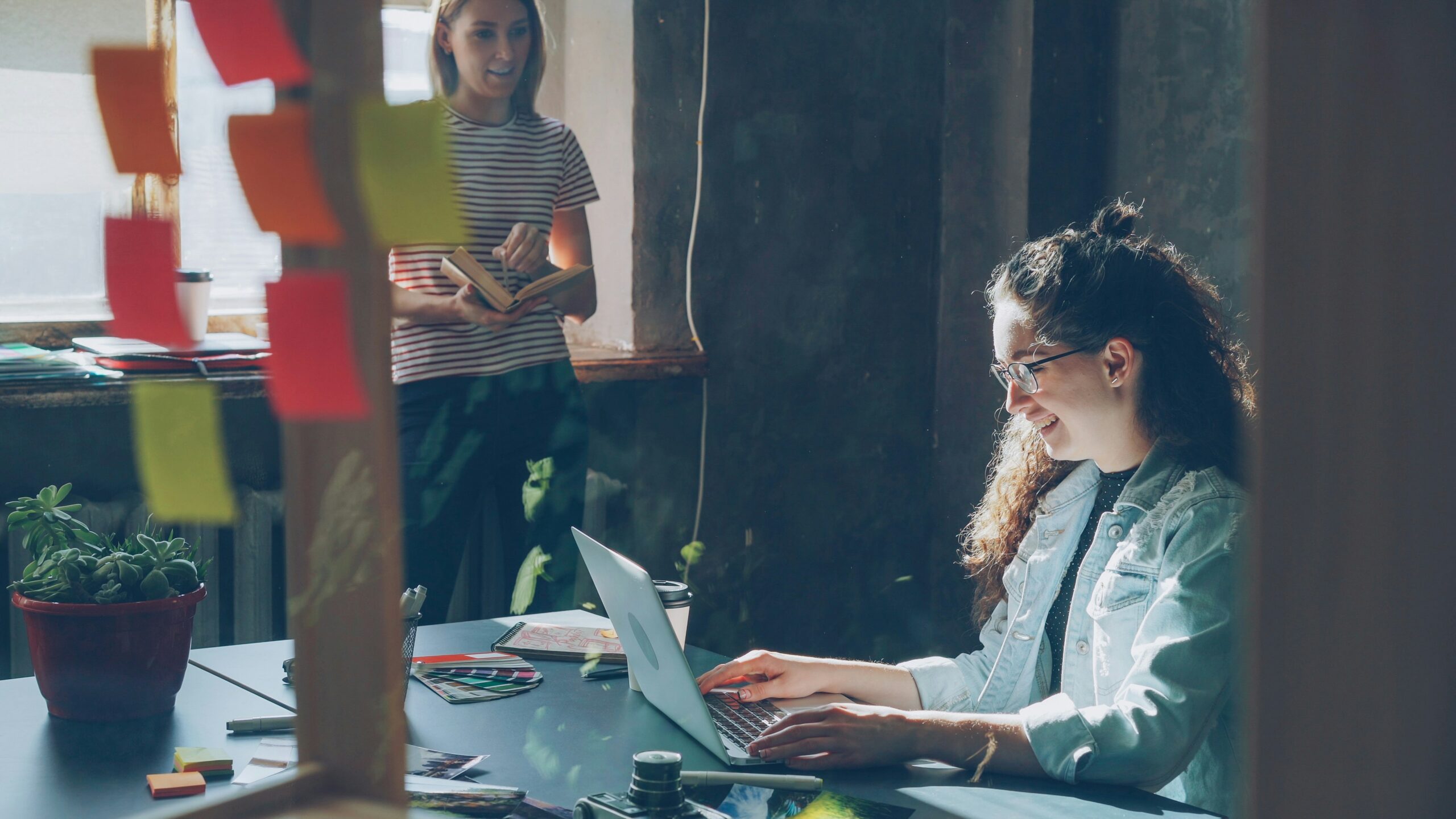 women sitting at desk working on laptop